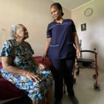 Carer supporting elder in her home