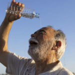 Old man keeping cool with water